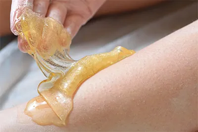 Sugaring-Paste wird auf die Haut aufgetragen